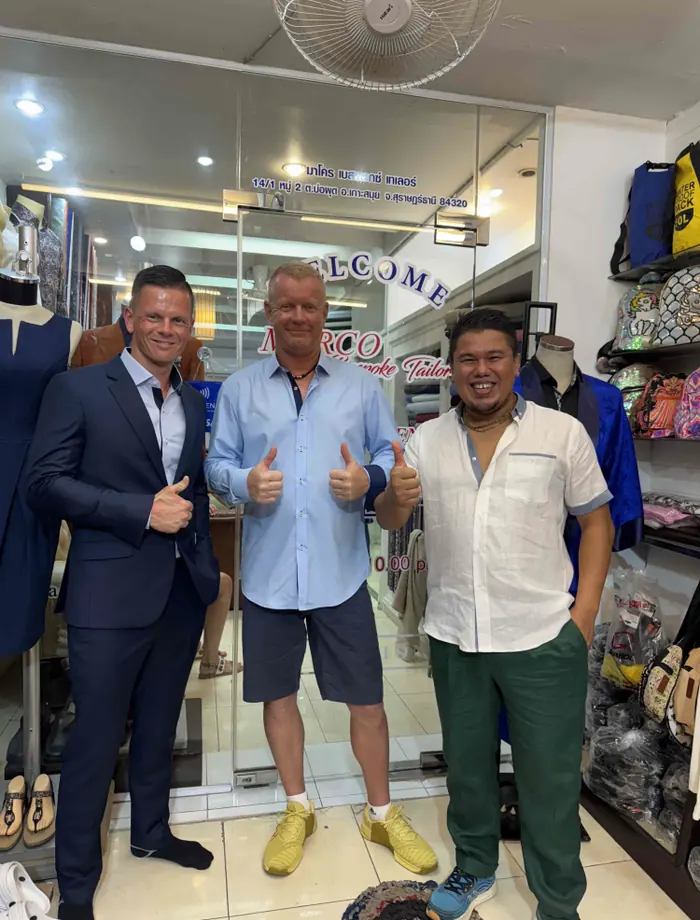 Marco, master tailor, with clients in his Koh Samui shop